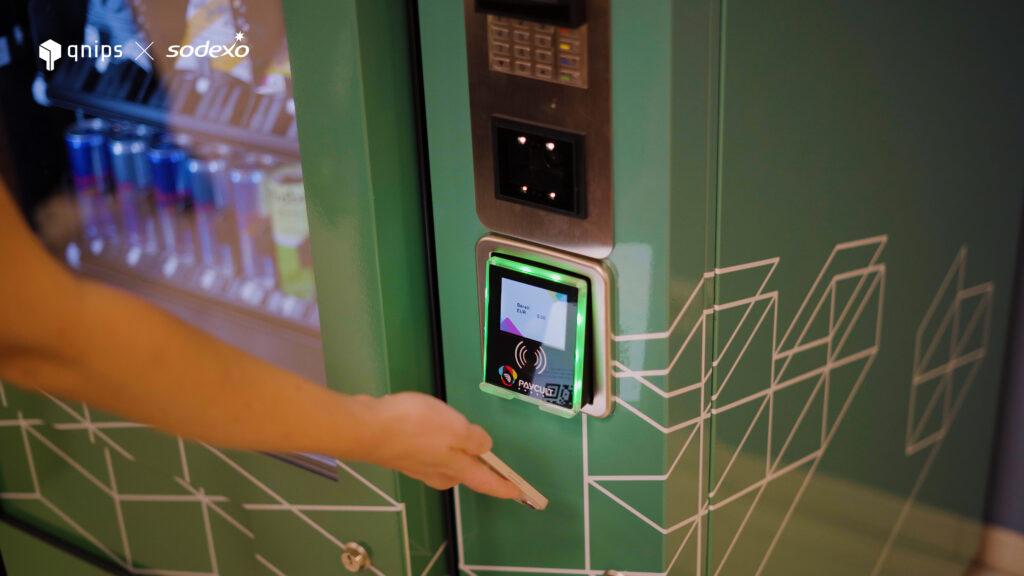 The image shows payment using a QR code in a mobile wallet at a drinks machine.